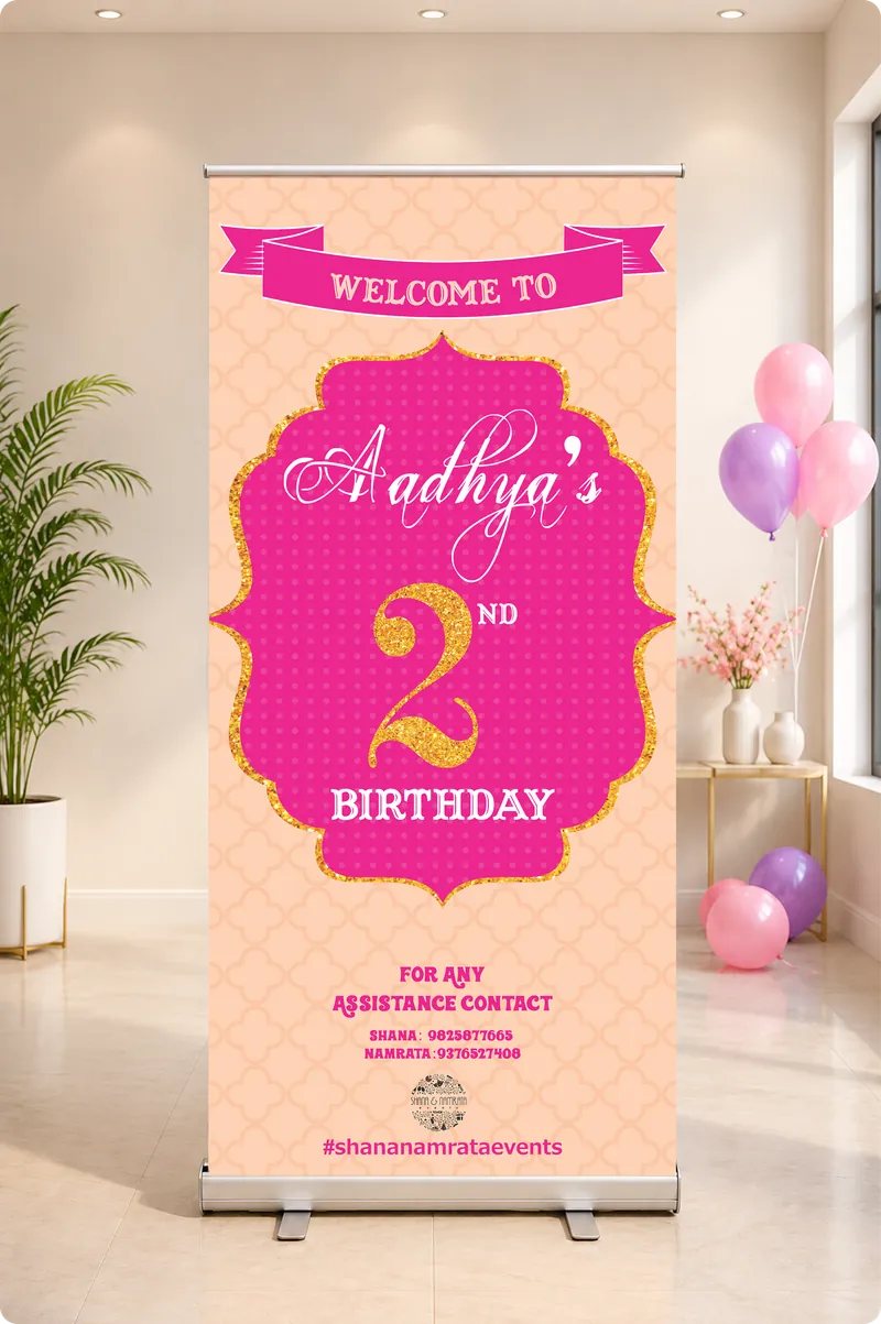 Aadhya's 2nd birthday roll-up welcome banner in pink and gold beside balloons