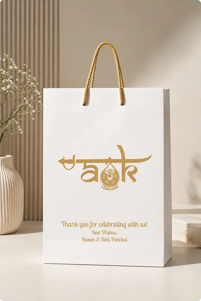 Anant & Khushali white gift bag with a gold AK monogram and a thank-you message