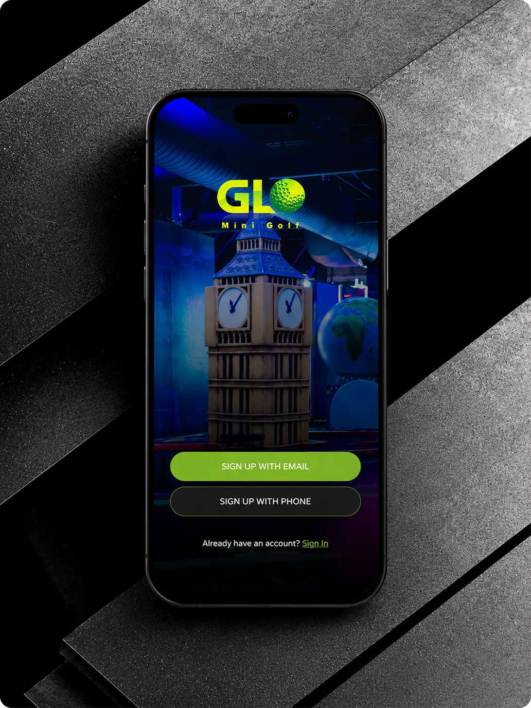 GLO Mini Golf app sign-up screen on a phone resting on a dark textured surface