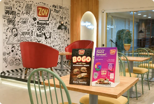 Zoy doodle wall art with red chairs and BOGO promotional standee